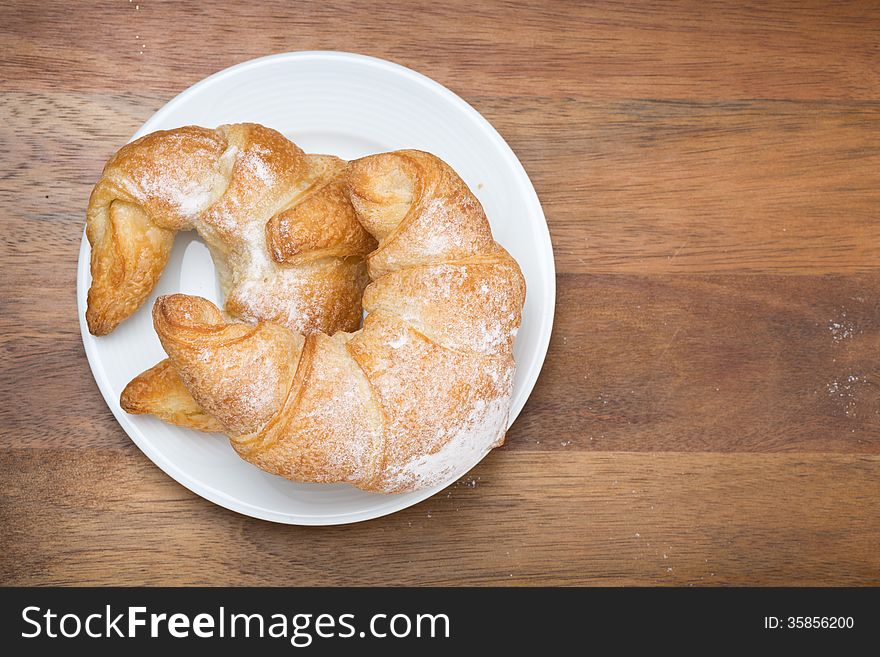 Croissants on a plate on a wooden background