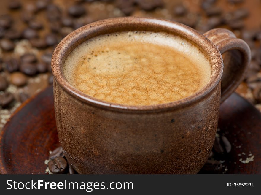 Cup of black coffee with foam, close-up, selective focus, horizontal