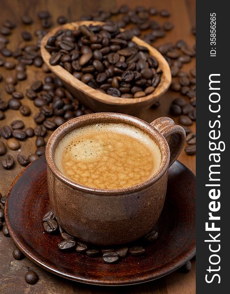 Cup of espresso and coffee beans, vertical