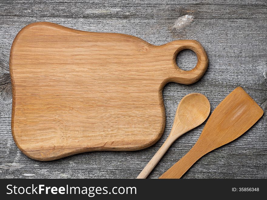 Figured wooden cutting board, spoon and spatula, concept, place for the recipe, top view