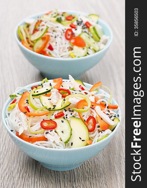 Two bowls of Thai salad with vegetables, rice noodle and chicken