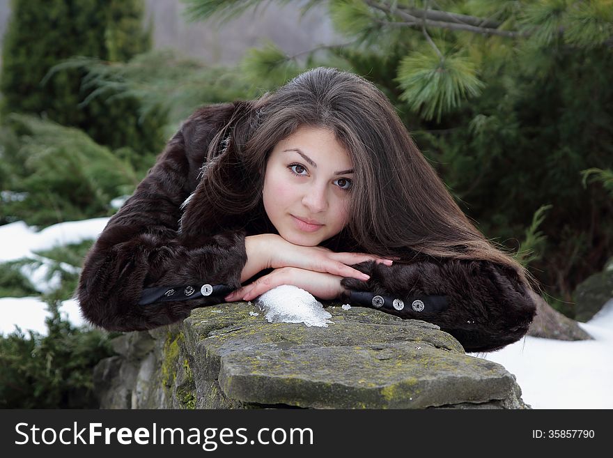 Beautiful girl in a fur coat and long hair looking gaze. Beautiful girl in a fur coat and long hair looking gaze