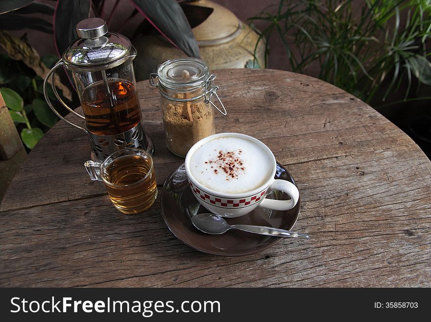 Coppuccino coffee and hot tea on wood table