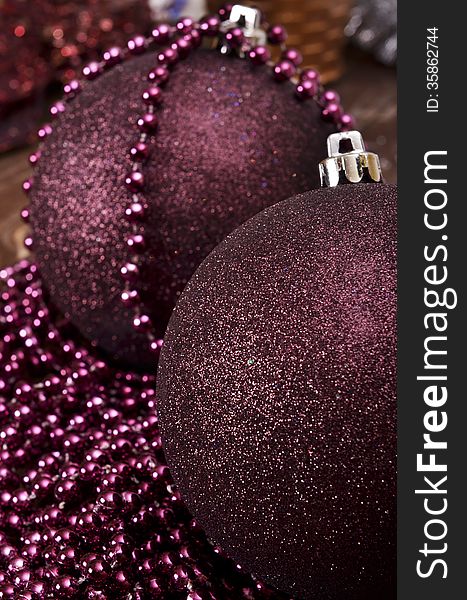 Large maroon christmas balls and beads on a wooden background
