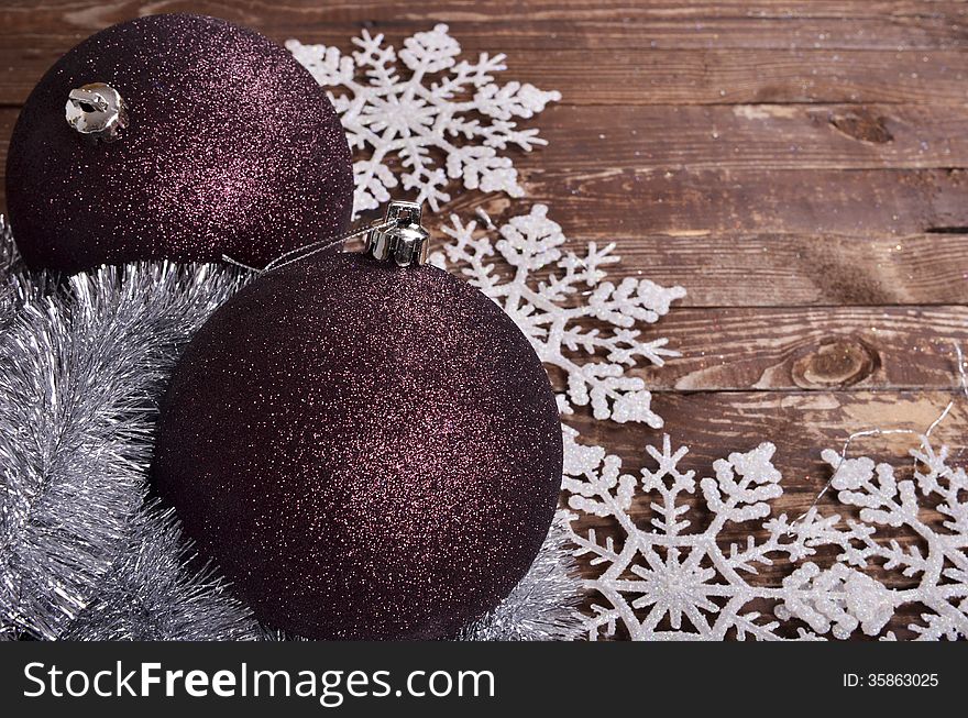 Maroon balls and snowflakes on a wooden background. Maroon balls and snowflakes on a wooden background