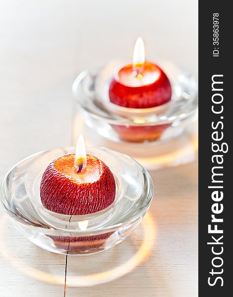 Close up of small red candles on a wooden table