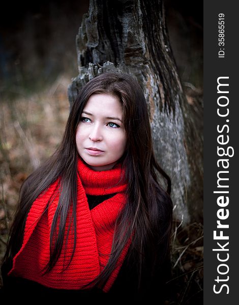 Portrait Of Woman In Red Scarf With Long Brunette Hair In Cold Dark Forest