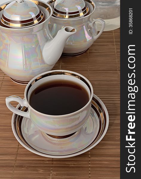 Black tea in white pearl tea utensils. Focus on cup