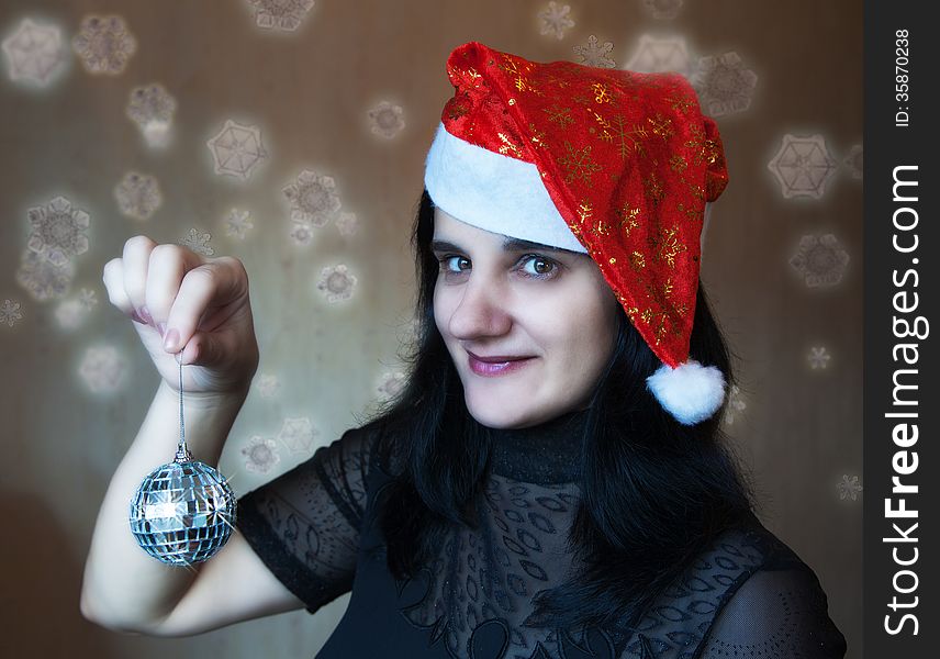 Young beautiful woman in Christmas cap holding a mirror ball. Young beautiful woman in Christmas cap holding a mirror ball