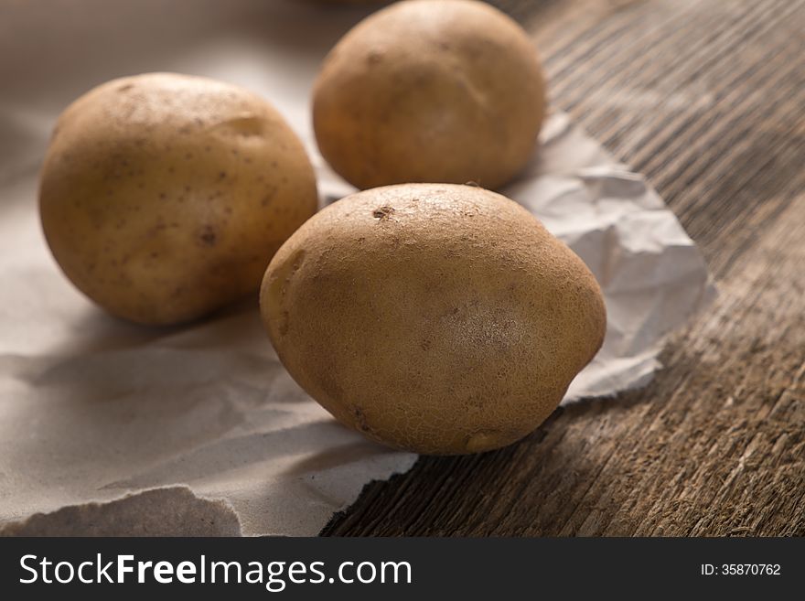 Fresh healthy whole raw potatoes on a sheet of crumpled brown paper. Fresh healthy whole raw potatoes on a sheet of crumpled brown paper