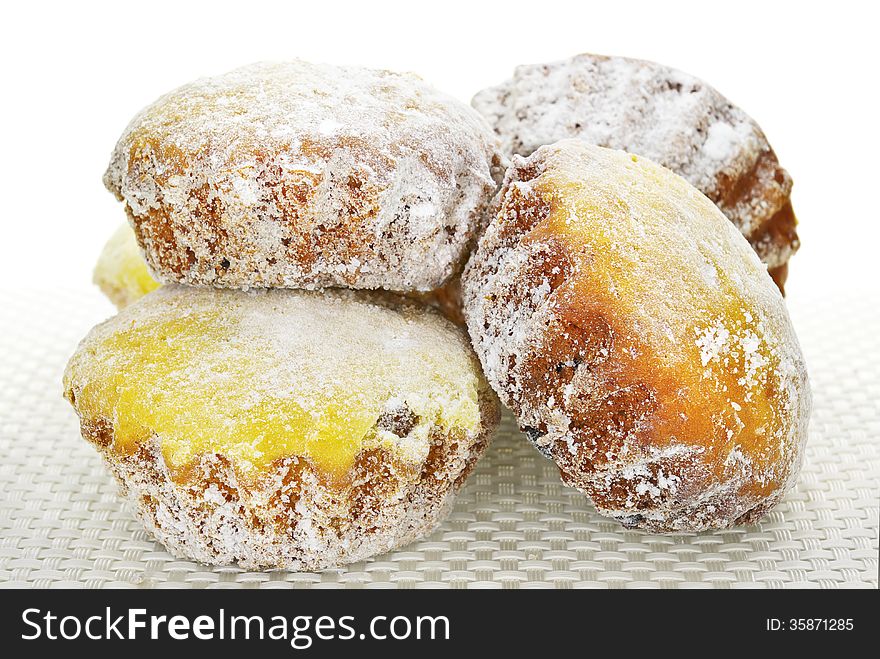 Cupcakes in powdered sugar on  tablecloth on a white background