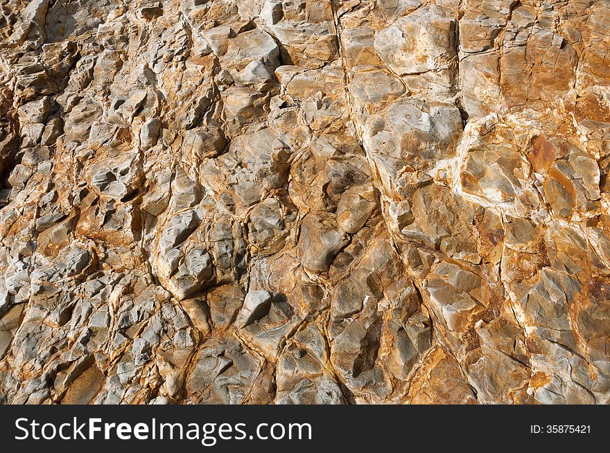 Image of the surface designated rock in the foreground, cracked, chipped, deepening. Image of the surface designated rock in the foreground, cracked, chipped, deepening