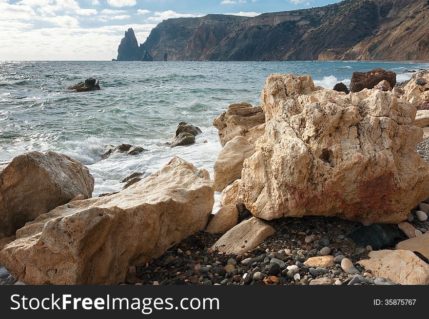 Ukraine, peninsula of Crimea, Sea coast on the Black Sea, large and small pebbles, large boulders, sea waves. Ukraine, peninsula of Crimea, Sea coast on the Black Sea, large and small pebbles, large boulders, sea waves