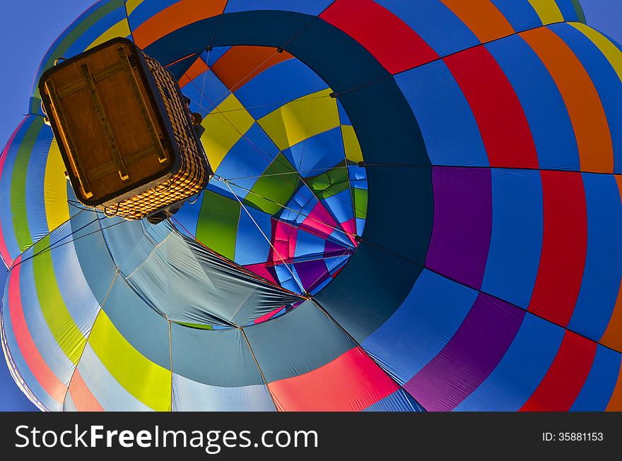 Multi-colored hot air balloon fills the morning sky over Arizona.