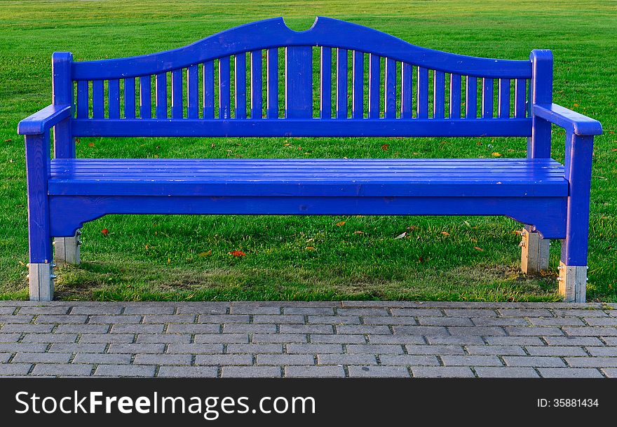 Blue wooden bench on green grass