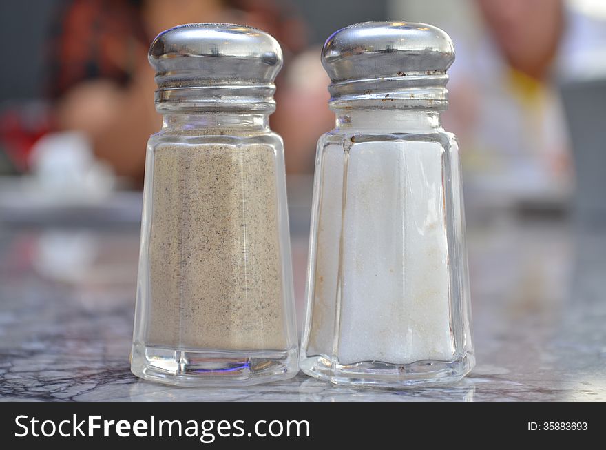 Glass salt and pepper shakers on table