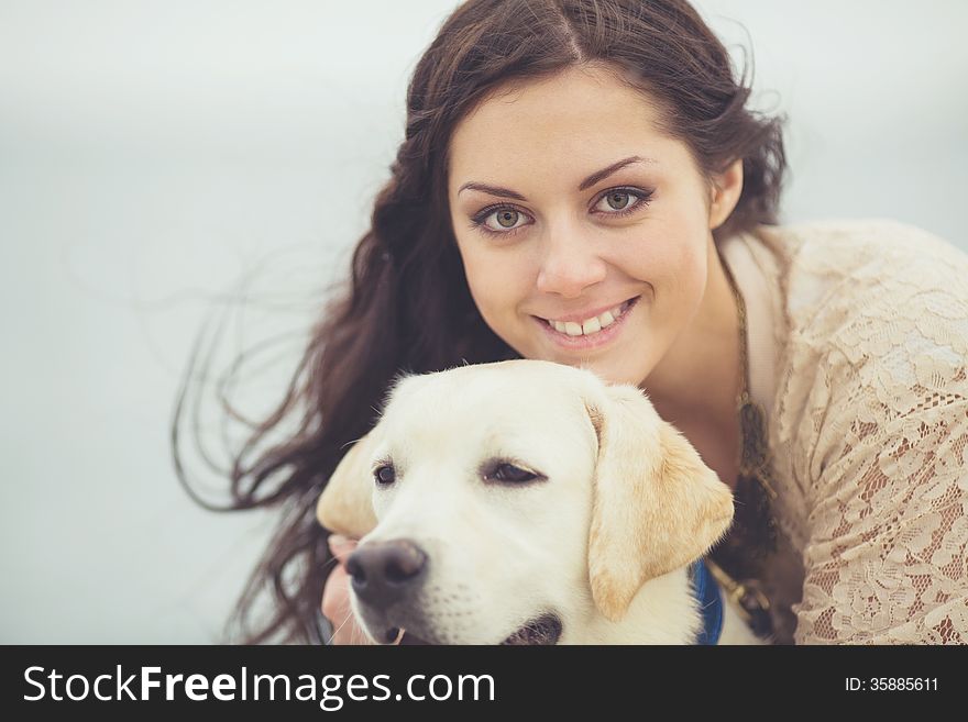 Portrait of beautiful young woman playing with dog on the sea shore. Portrait of beautiful young woman playing with dog on the sea shore