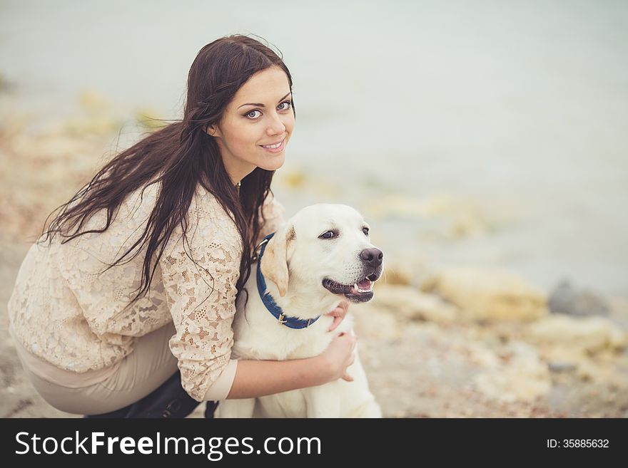 Portrait of beautiful young woman playing with dog on the sea shore. Portrait of beautiful young woman playing with dog on the sea shore