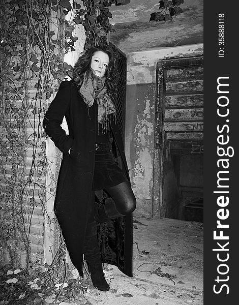 Model posing in long coat in abandoned place. Model posing in long coat in abandoned place