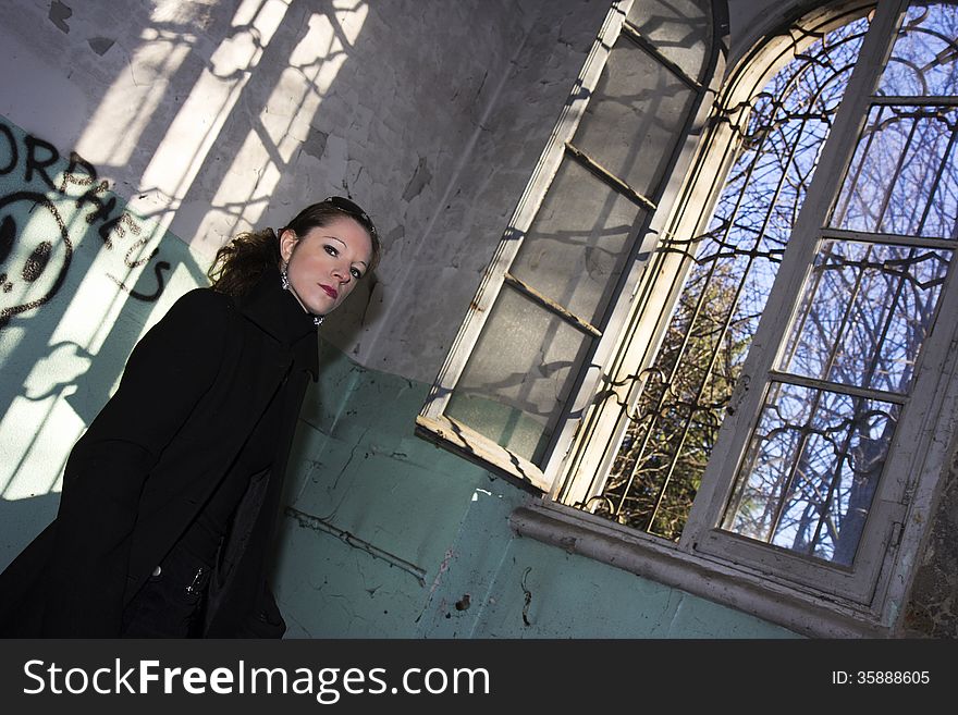 Model posing in long coat in abandoned place. Model posing in long coat in abandoned place