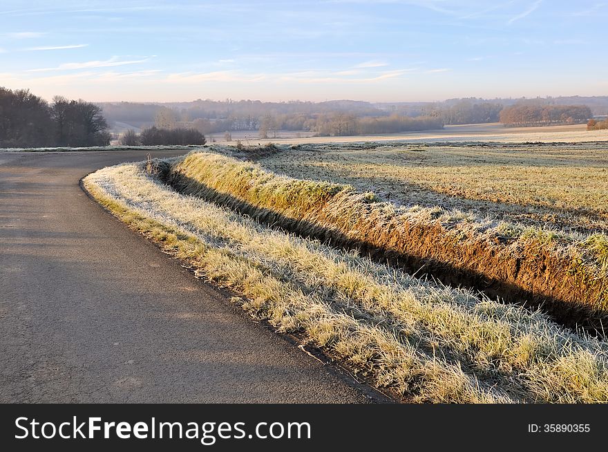 Country lane through the frost covered field