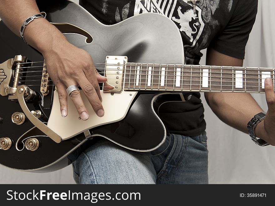 Male strumming on a guitar. Male strumming on a guitar