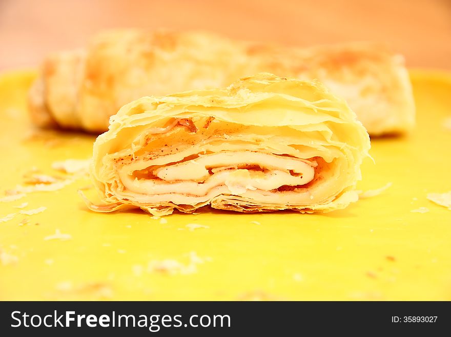 Sliced â€‹â€‹apple strudel on a yellow platter