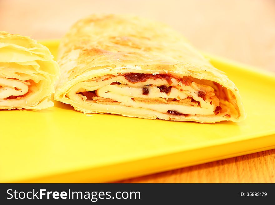 Sliced â€‹â€‹apple strudel on a yellow platter