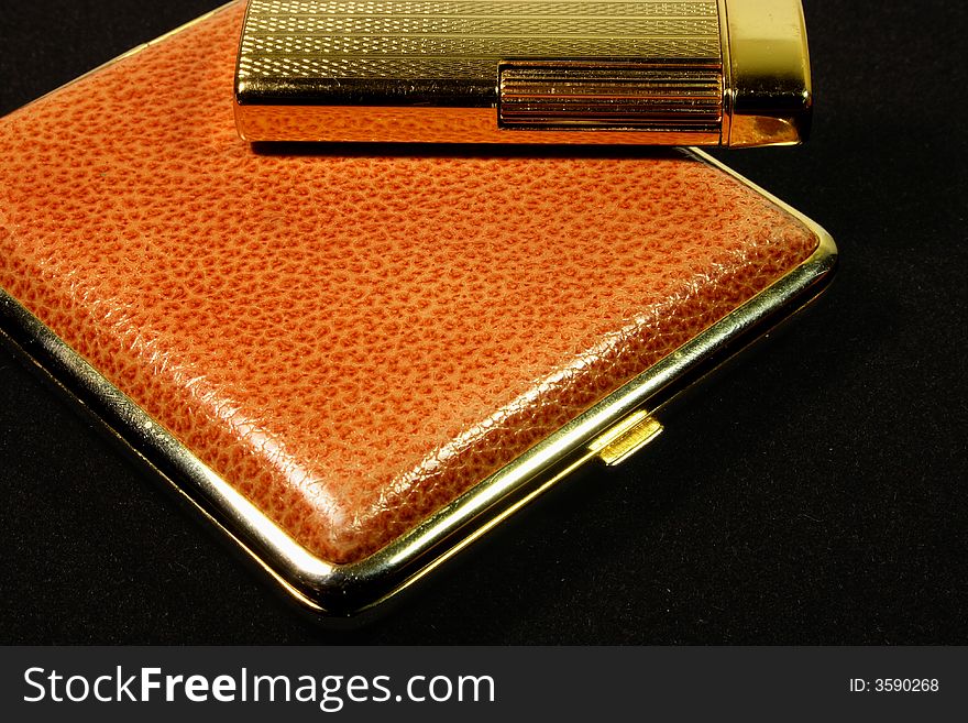 Cigarette-case and lighter on black background