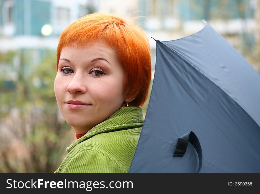 Young red-haired woman with umbrella
