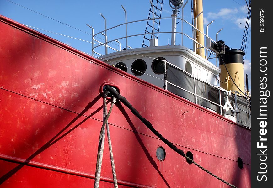 A side view of a red tug boat at the South Street Seaport. A side view of a red tug boat at the South Street Seaport