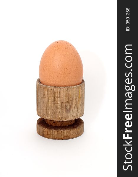 Brown egg in a wooden stand