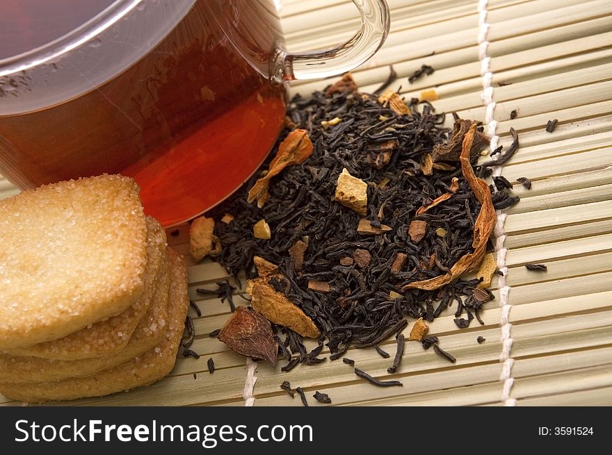 Glass tea, dried tea leaves and cookies. Glass tea, dried tea leaves and cookies