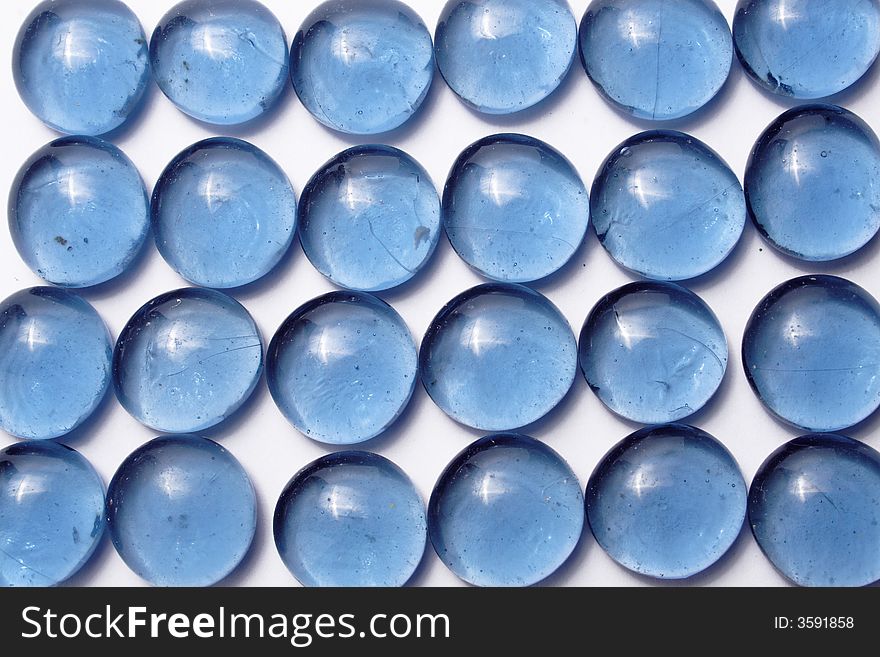 Blue glass pebbles on the white background