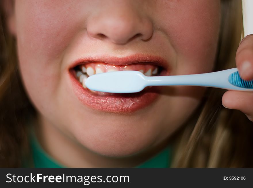 Closeup of older child brushing teeth