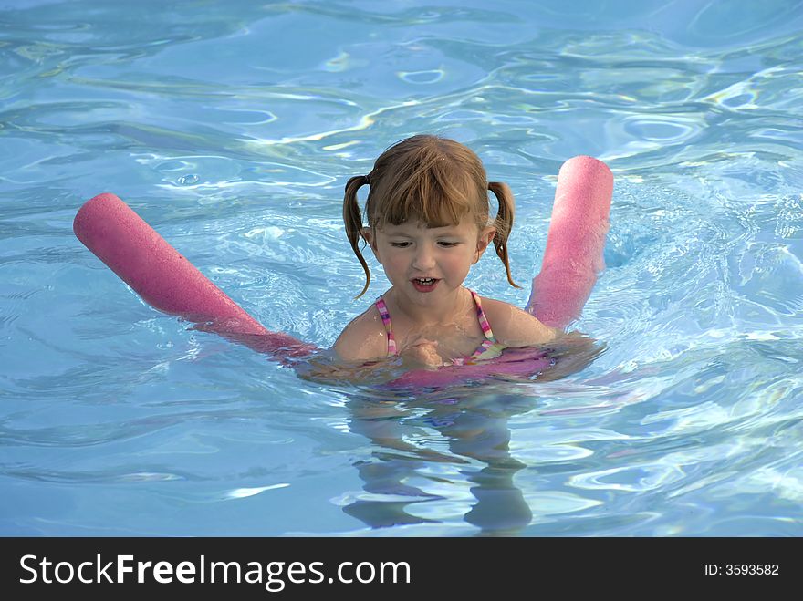 Young girl in swimming pool flipping wet hair. Young girl in swimming pool flipping wet hair