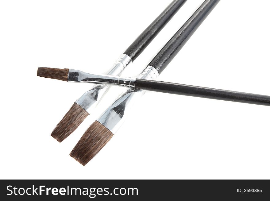 Closeup of three brushes of different sizes isolated on white
