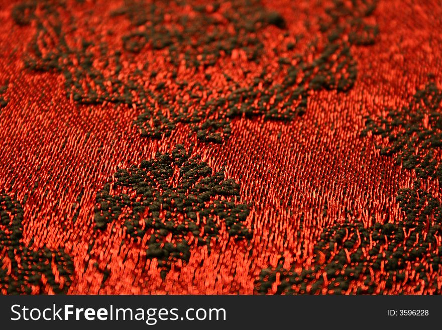 Red blanket with black ornaments, a detail.