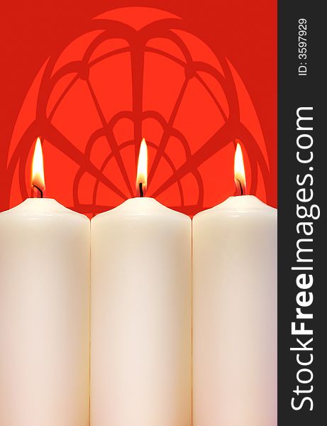 Three white holidays candles on a red background