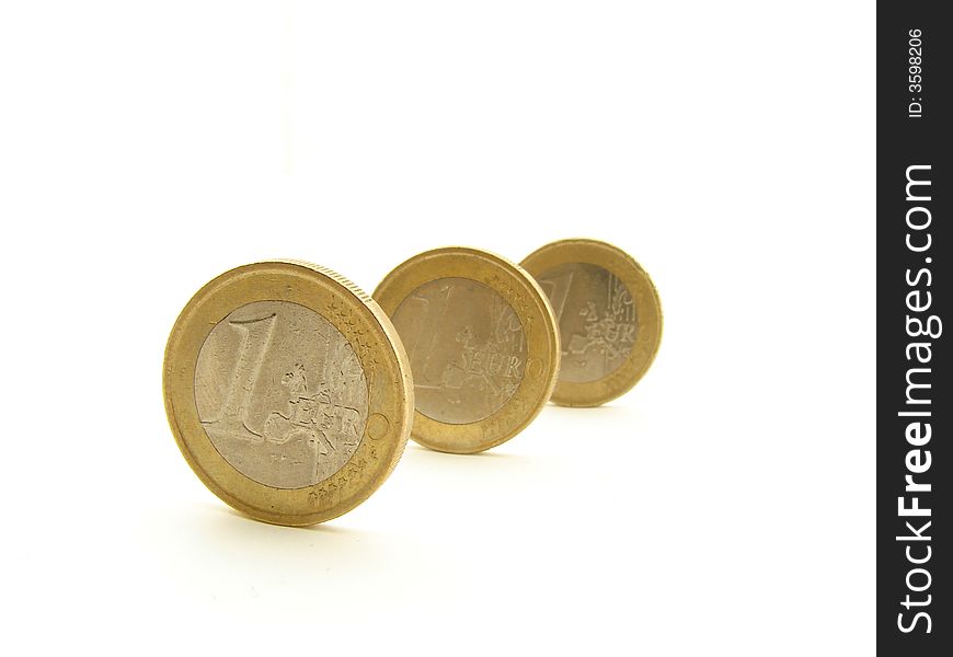 Three coins standing in the row, representing European Union currency. Three coins standing in the row, representing European Union currency.