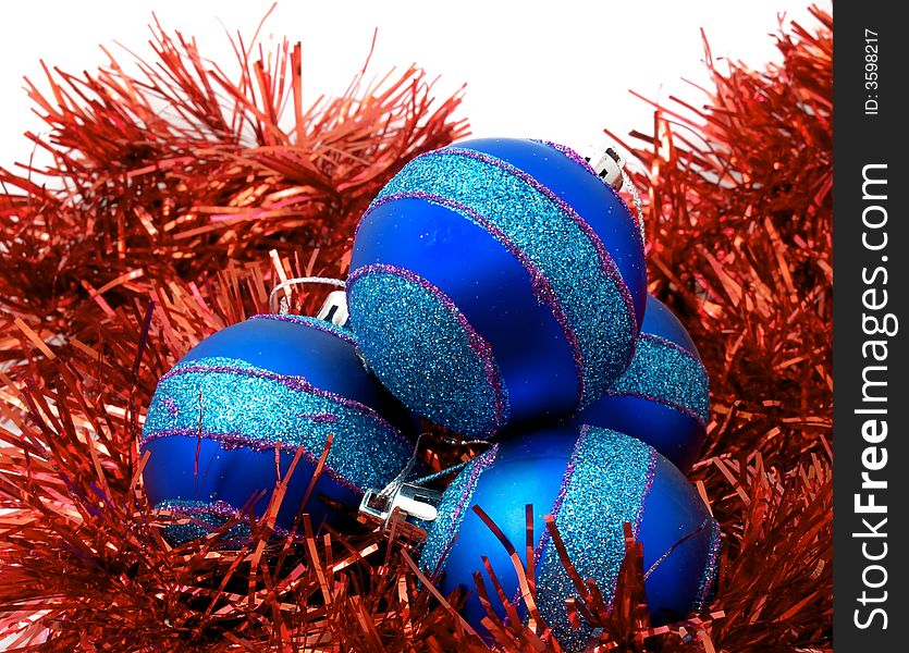 Christmas blue ornaments and red tinsel on white background