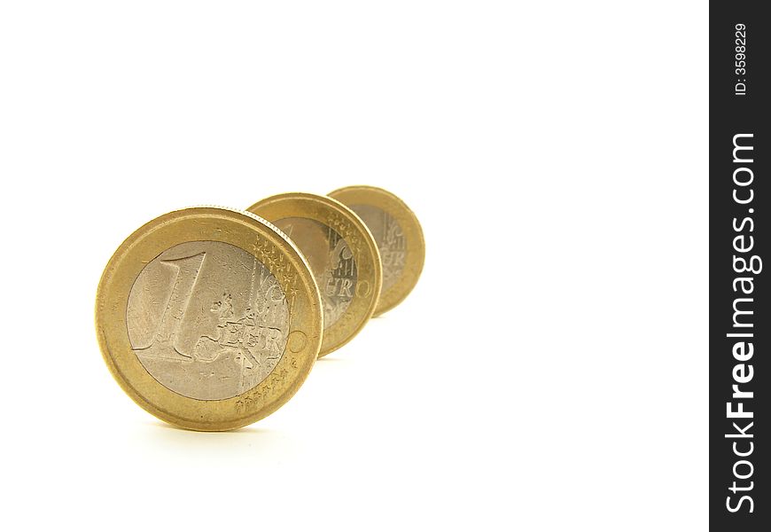 Three coins standing in the row, representing European Union currency. Three coins standing in the row, representing European Union currency.