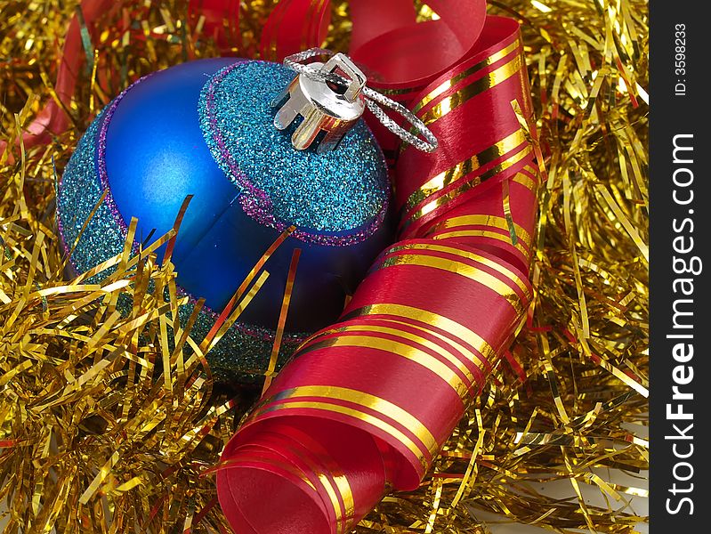 Christmas blue ornaments and colorfull  ribbon on background of gold tinselbackground. Christmas blue ornaments and colorfull  ribbon on background of gold tinselbackground