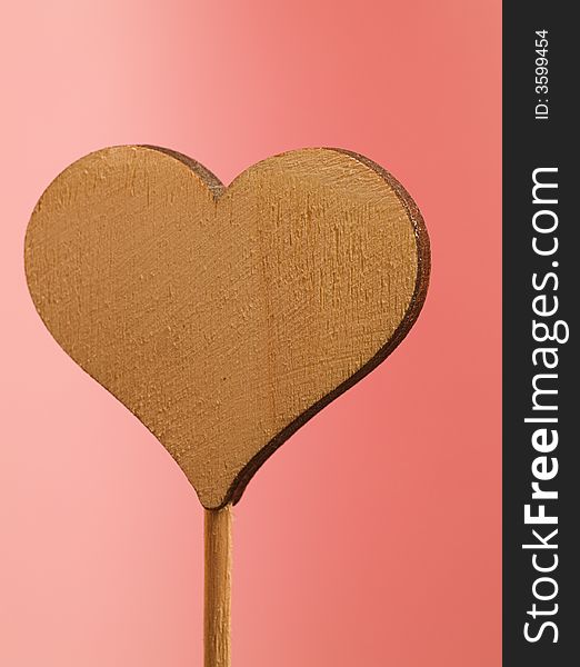 The wooden heart on a pink background