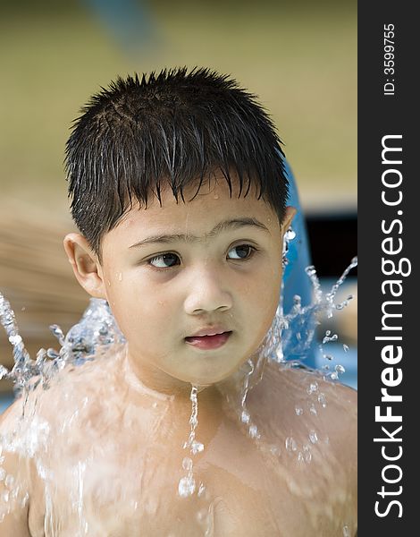 Kid playing with water fountain inside swimming pool. Kid playing with water fountain inside swimming pool