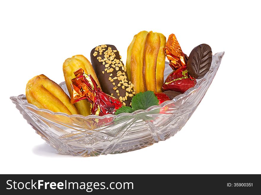 Crystal vase filled with tasty cakes and sweets . Presents on a white background. Crystal vase filled with tasty cakes and sweets . Presents on a white background...