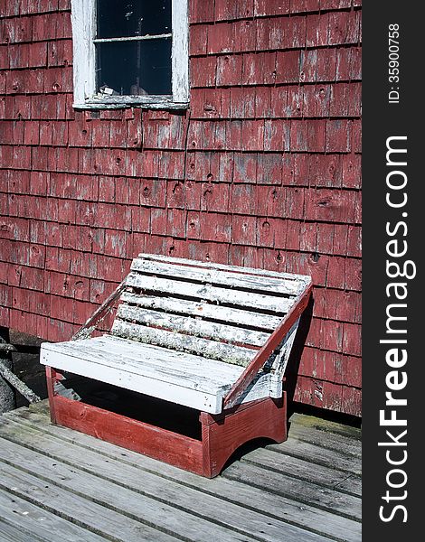 Old wooden bench against a red building. Old wooden bench against a red building