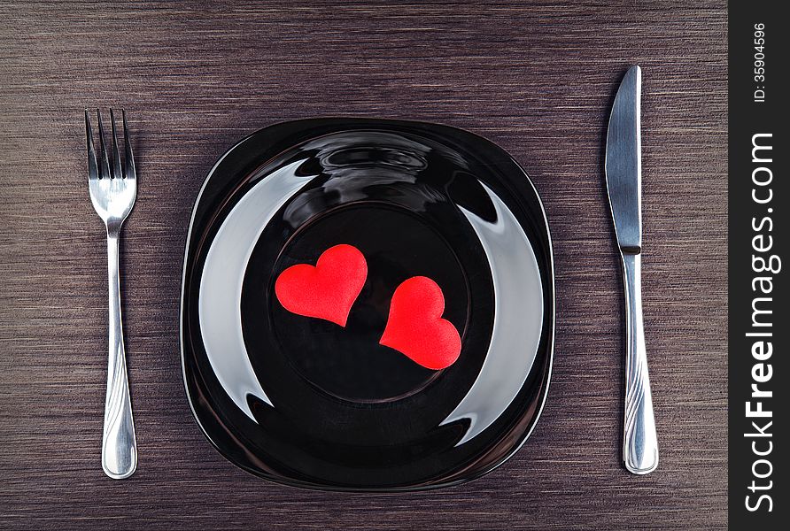 Table setting for Valentine's Day. plate, fork, knife and red heart