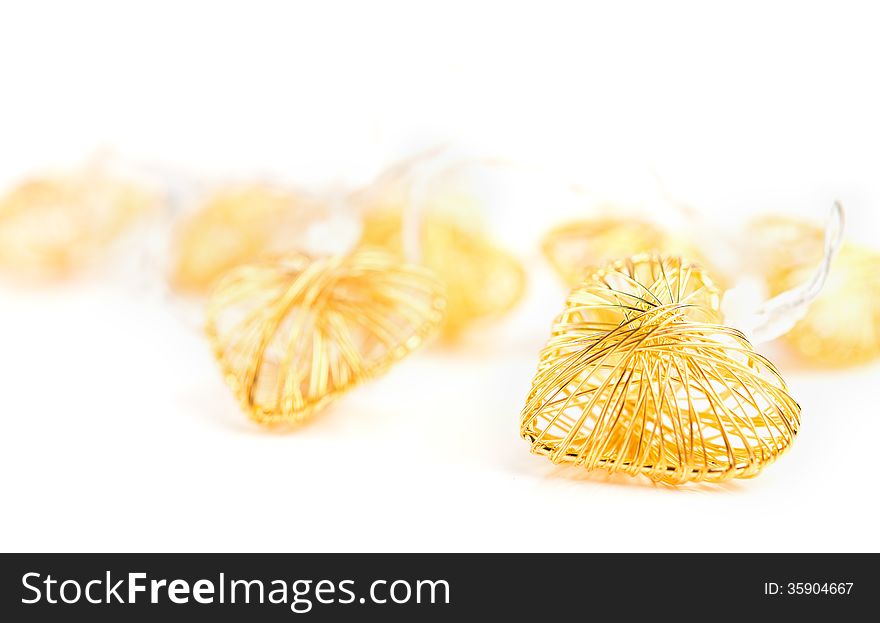 Braided gold decorative hearts on white background