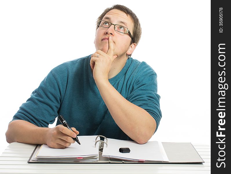 One man sitting at a desk thinking about things doing paperwork. One man sitting at a desk thinking about things doing paperwork